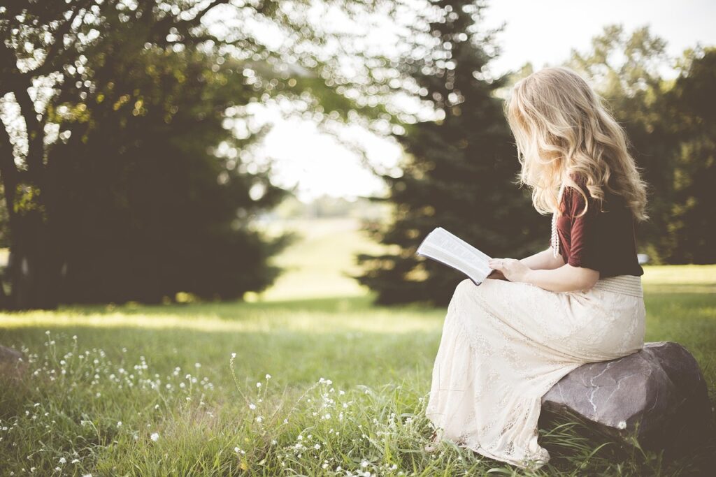 blonde woman reading in nature